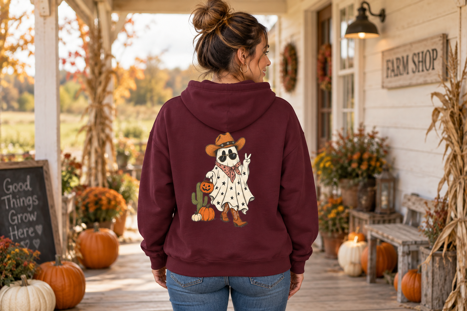 Woman wearing the burgundy Cowboy Ghost Hoodie on an autumn porch
